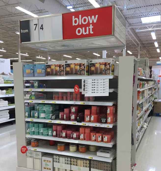 Retail store endcap display for a clearance  of candle with a sign reading ‘blowout’!